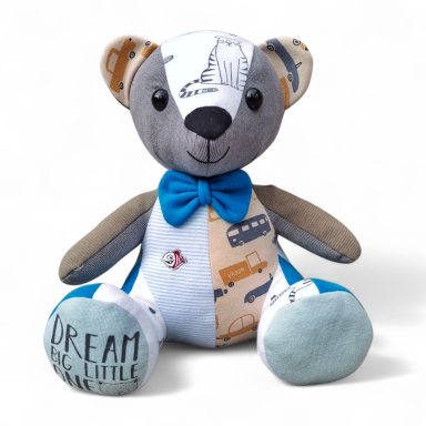 Schattige teddybeer met een blauw strikje en een patchwork patroon.