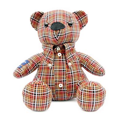 Een gebreide teddybeer met een schotse ruitmotief en knoopjes op de voorzijde.